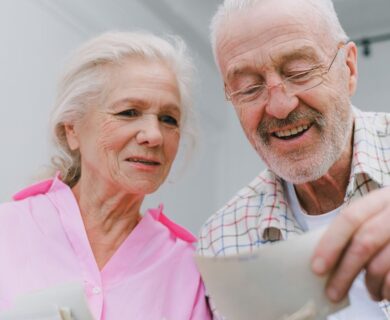 Happy senior couple enjoying old photographs and sharing memories together.