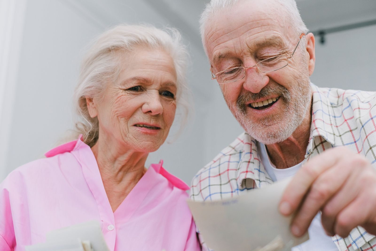 Happy senior couple enjoying old photographs and sharing memories together.