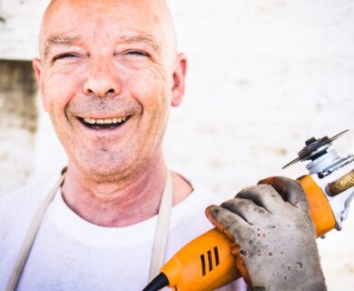 man holding orange angle grinder