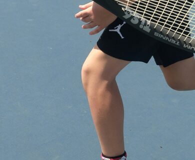 a man holding a tennis racquet on top of a tennis court